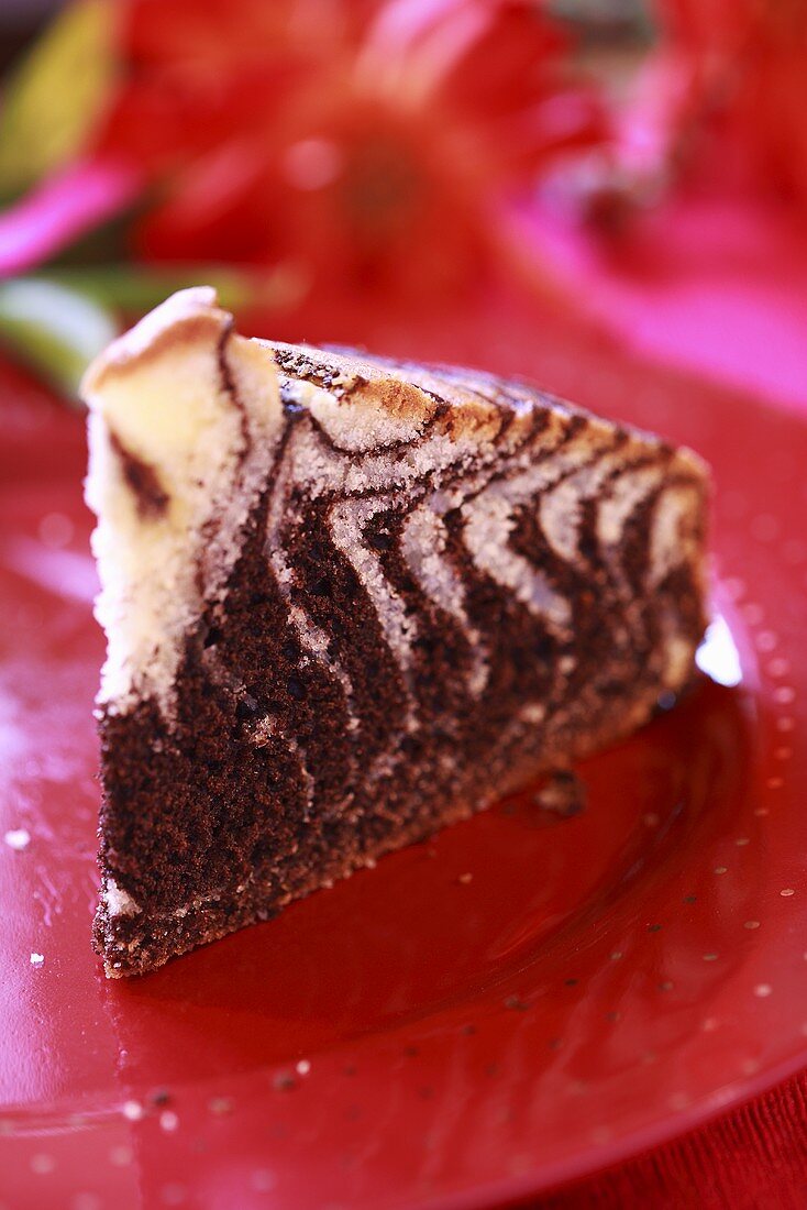 A slice of marble cake on a red plate