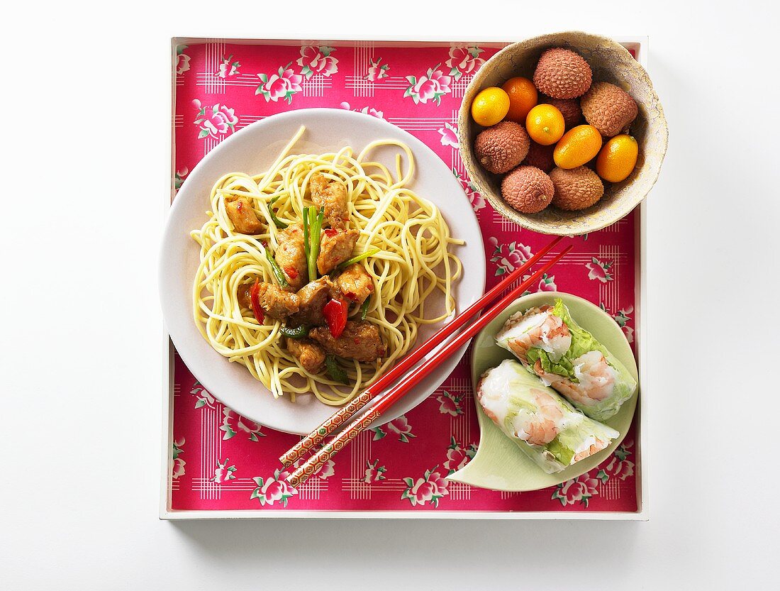 Egg noodles with pork, spring rolls and exotic fruit