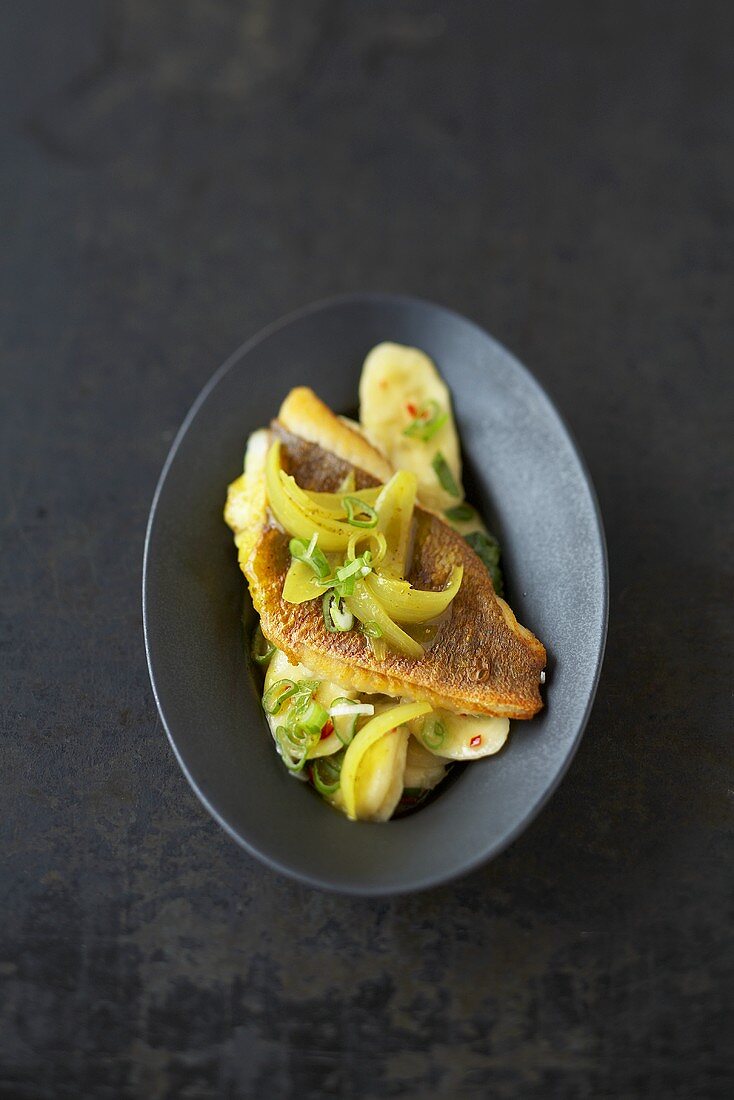 Gebratener Red Snapper auf Bananensalat mit Curry-Zwiebeln