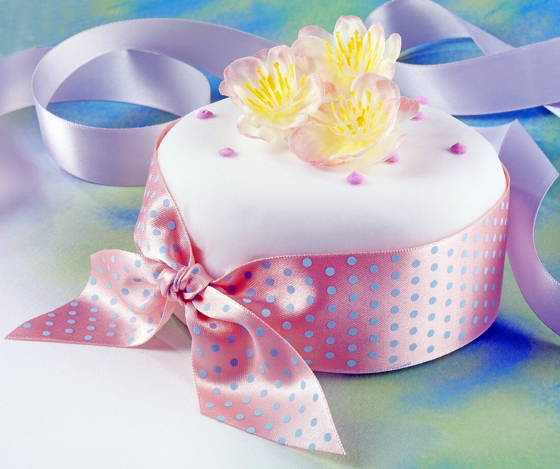 Cake covered in fondant icing with bow