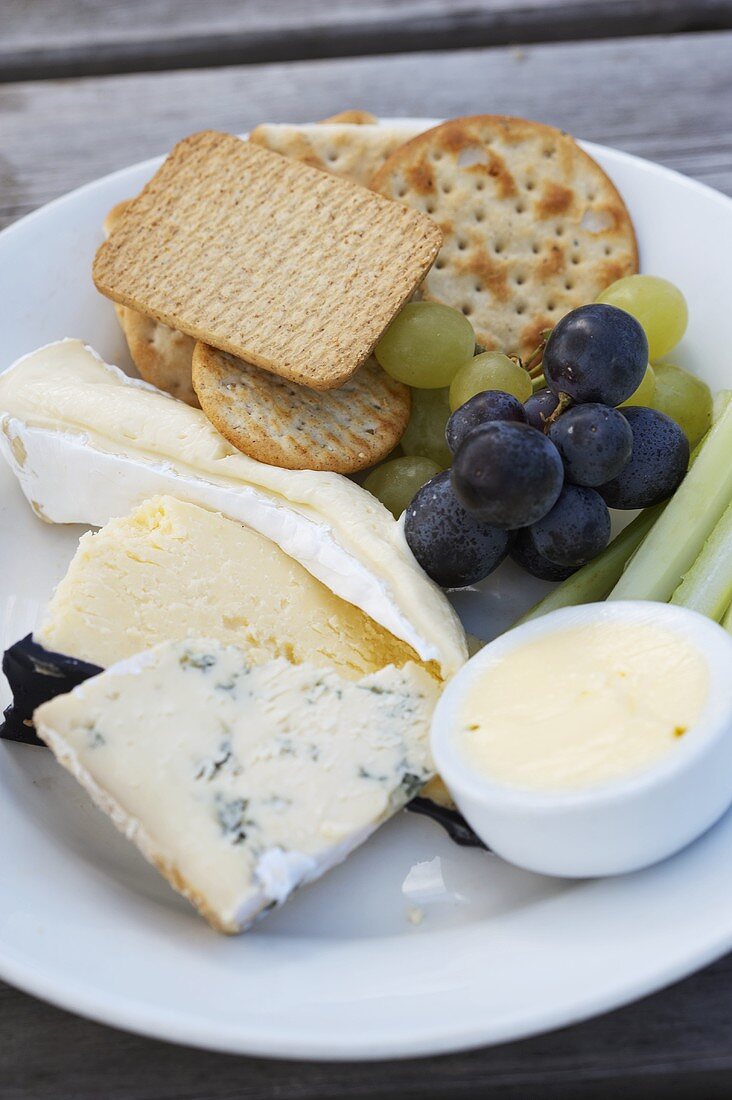 Cheese platter with crackers and grapes