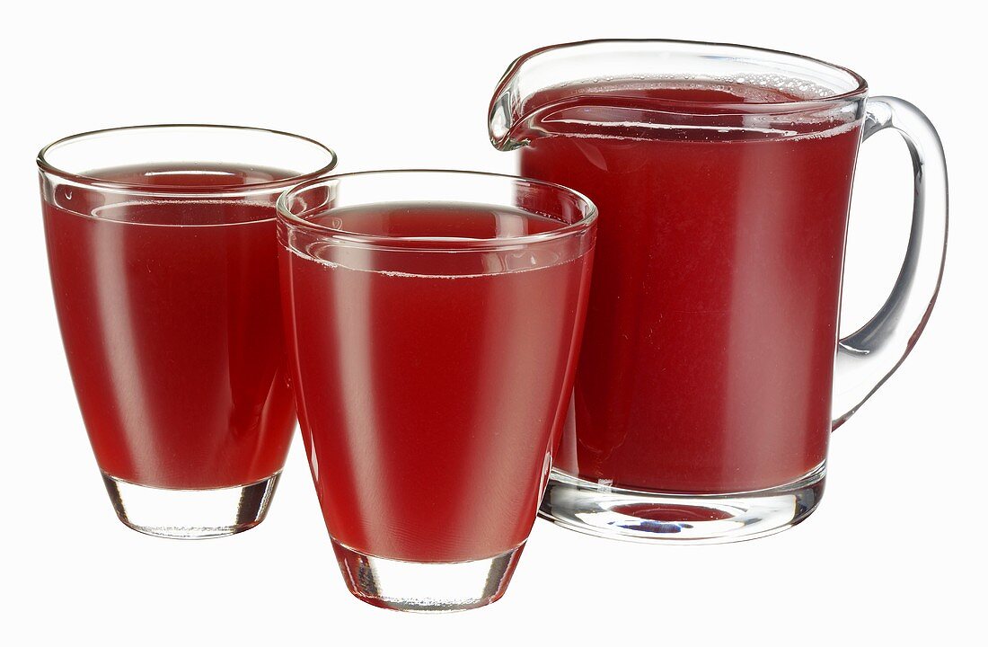 Cranberry juice in jug and two glasses