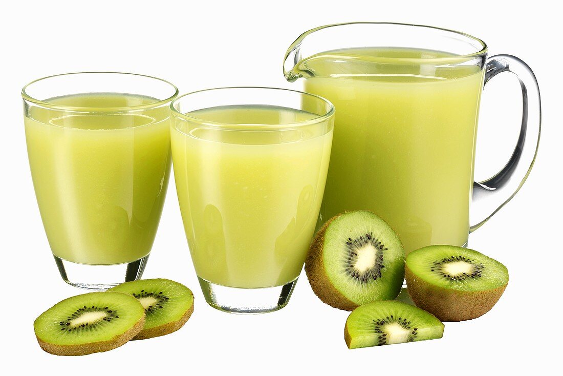Kiwi fruit juice in jug and two glasses & fresh kiwi fruit