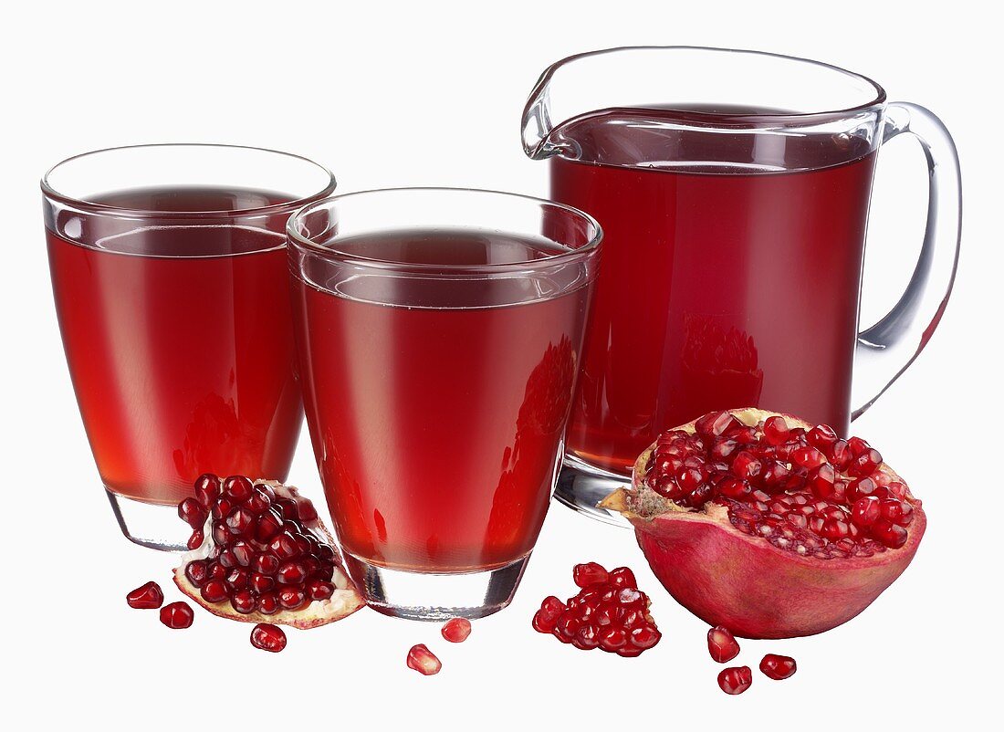 Pomegranate juice in jug & two glasses, fresh pomegranate