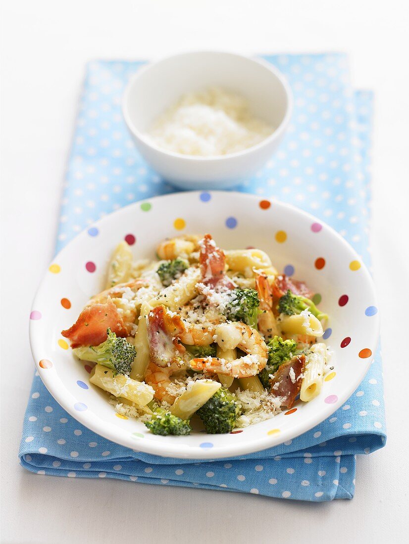 Penne with prawns, broccoli and cheese in spotted dish