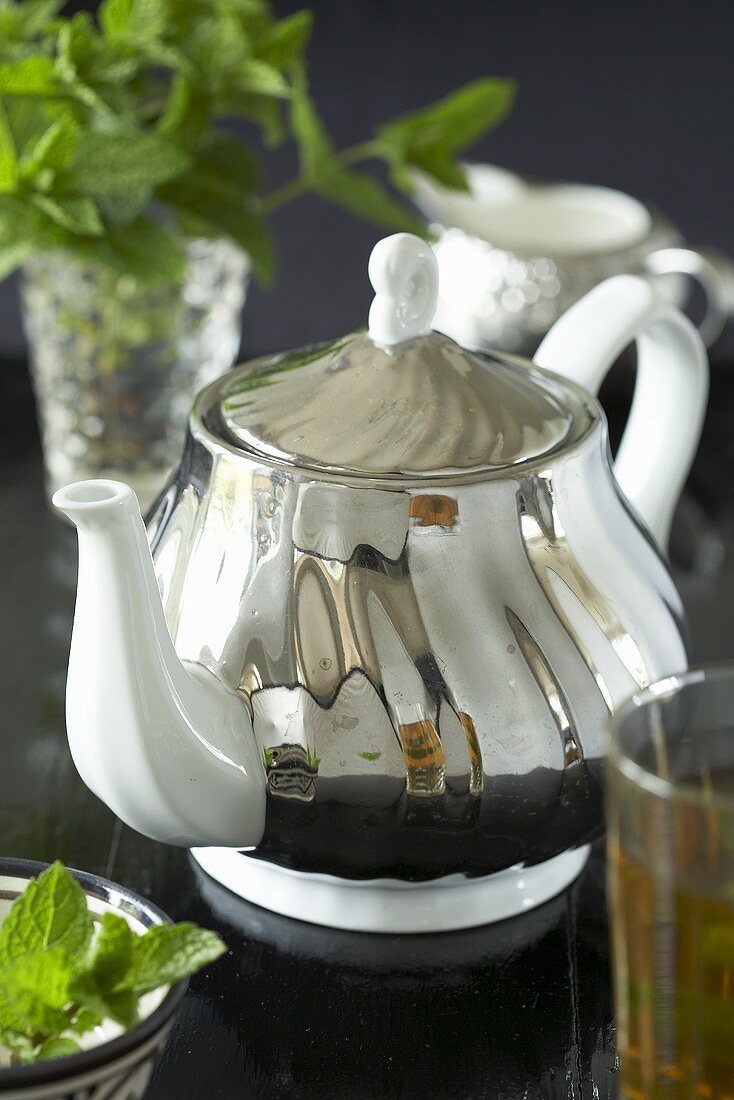 Silver teapot with glass of mint tea