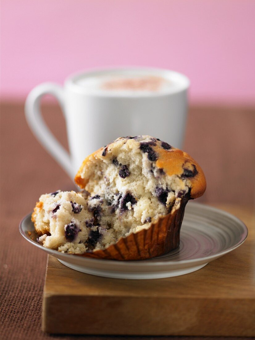 A blueberry muffin with a mug of coffee