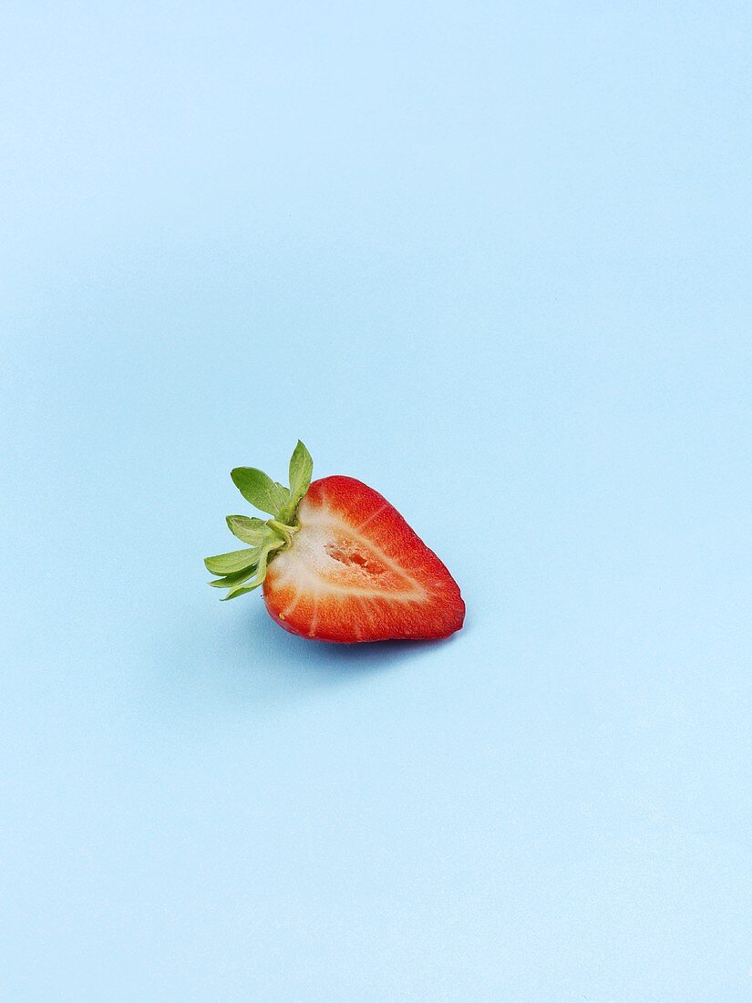 Eine halbe Erdbeere auf blauem Hintergrund