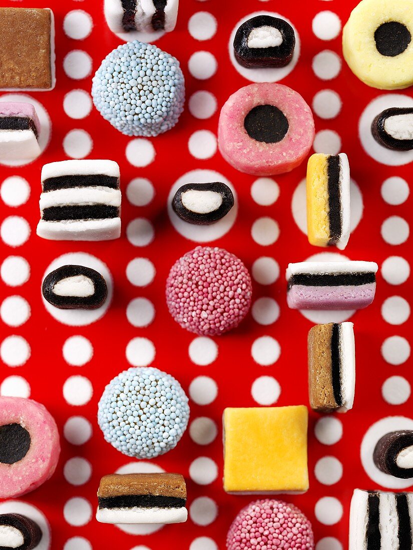 Liquorice allsorts on red and white patterned background