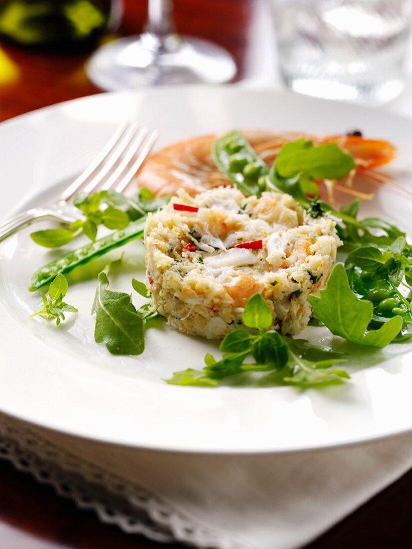 Prawn cake with young peas and rocket