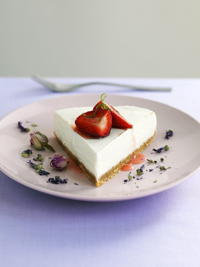 Piece of cheesecake with strawberries and lavender flowers