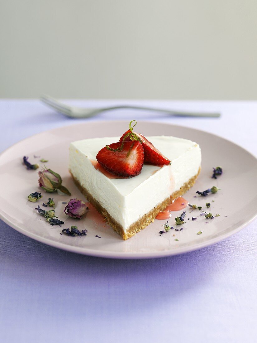 Stück Käsekuchen mit Erdbeeren und Lavendelblüten