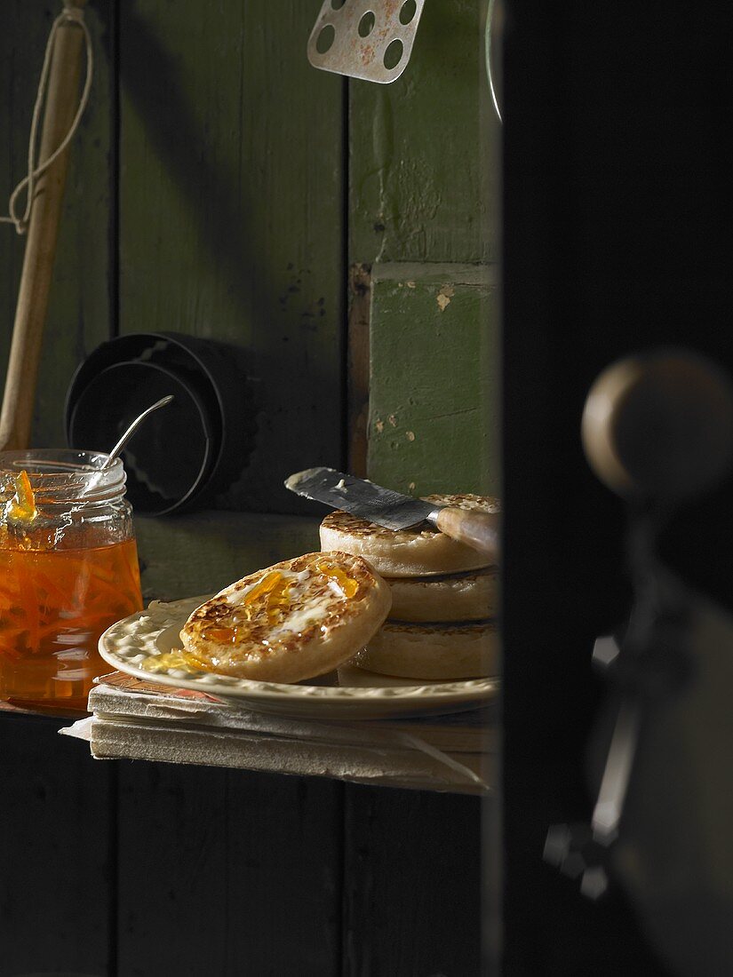 Buttered crumpets with orange marmalade in a pantry