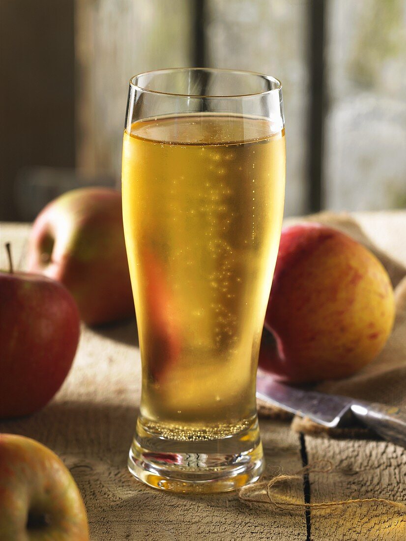 A glass of ice-cold cider with apples