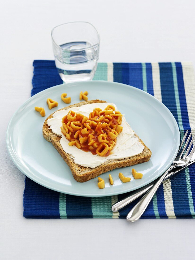 Bread with cream cheese and alphabet pasta for children