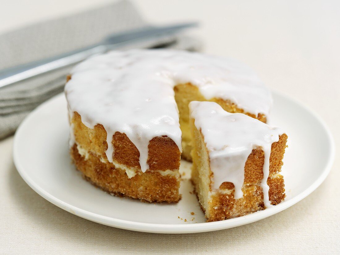 Lemon cake with icing, partly sliced