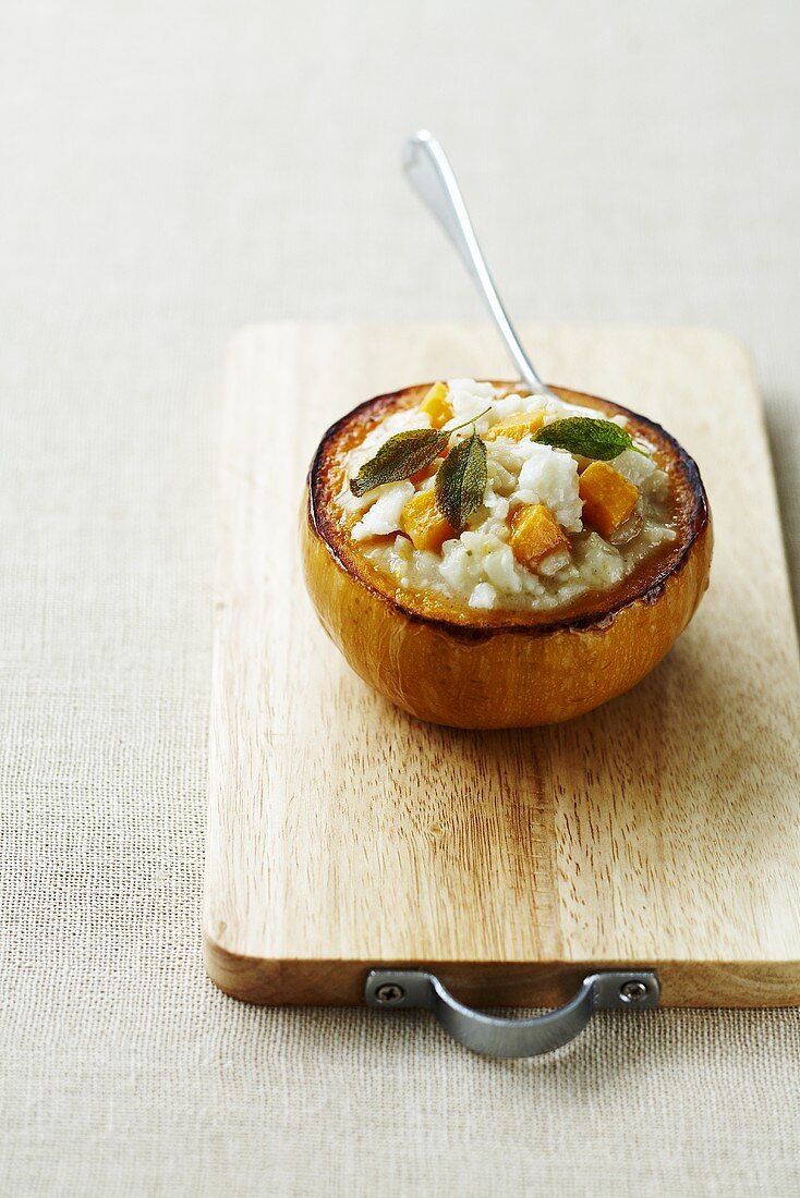 Pumpkin risotto with sage served in a hollowed out pumpkin