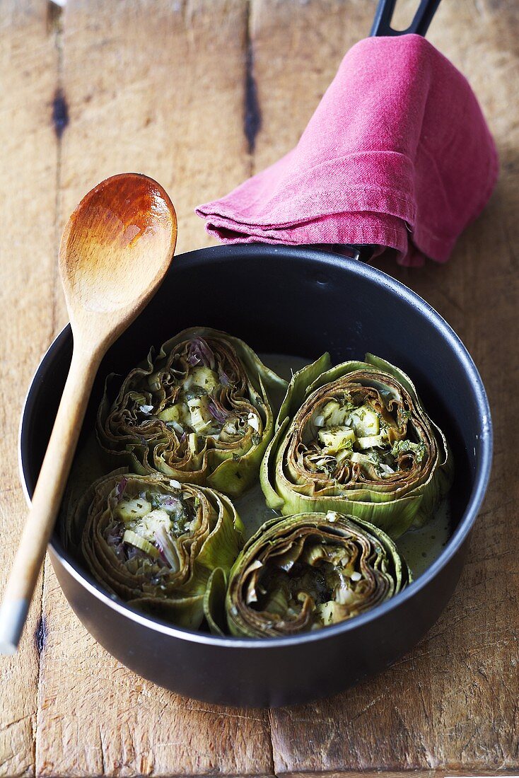 Artichokes with cheese and butter in a pan