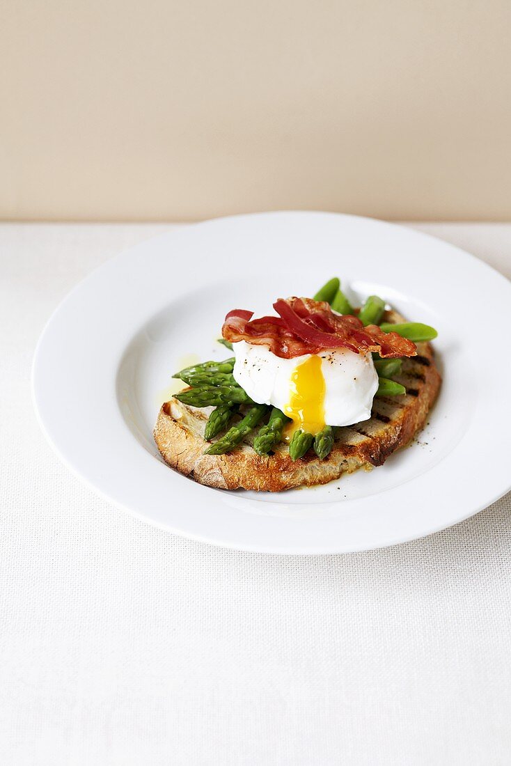 Toast with green asparagus, egg and bacon