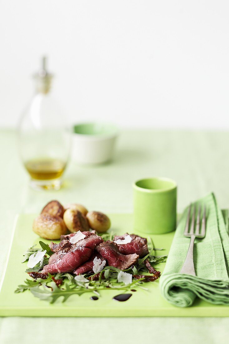 Roastbeef in Scheiben auf Rucola mit Parmesan, Ofenkartoffeln