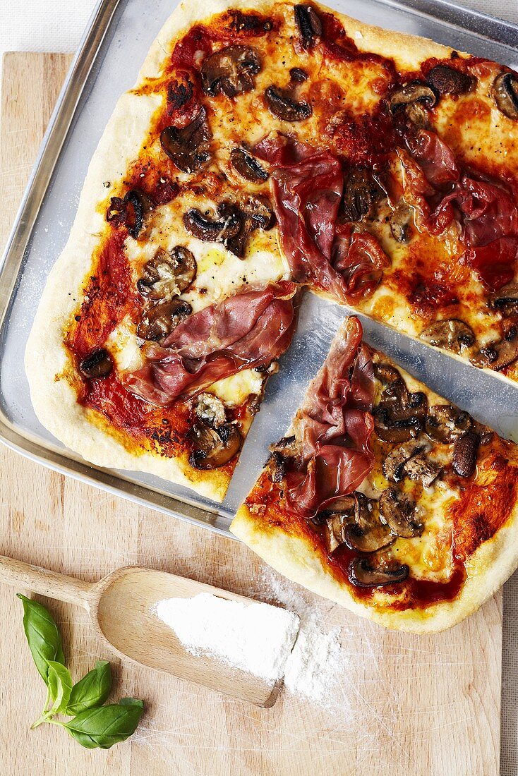 Pizza topped with Parma ham and mushrooms (overhead view)