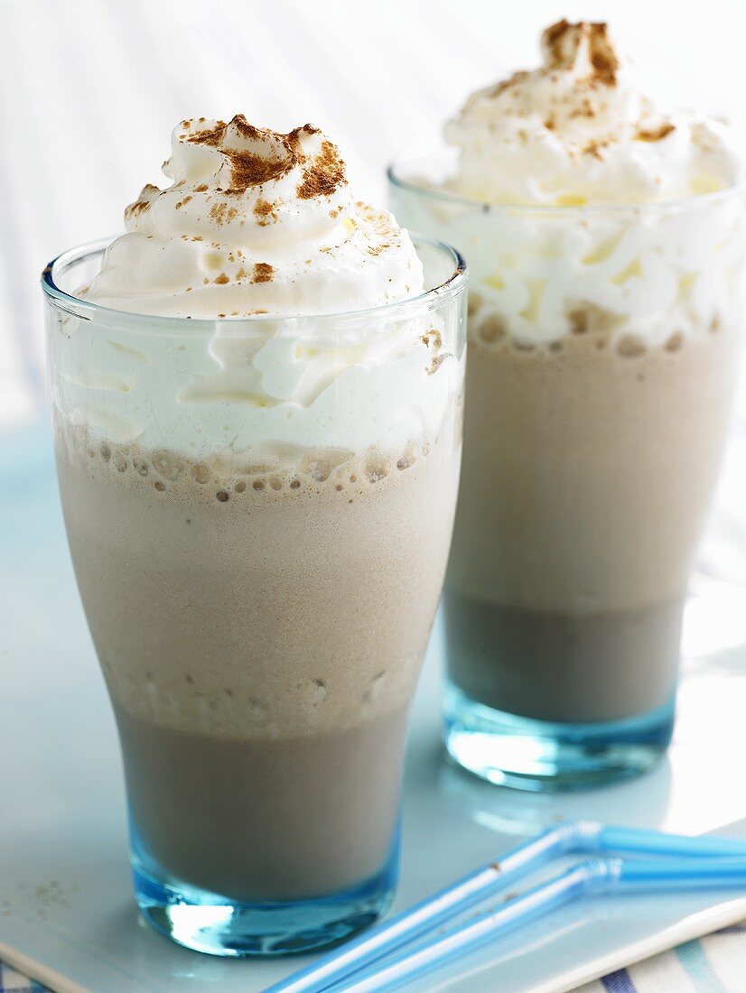 Two glasses of chocolate frappé with whipped cream