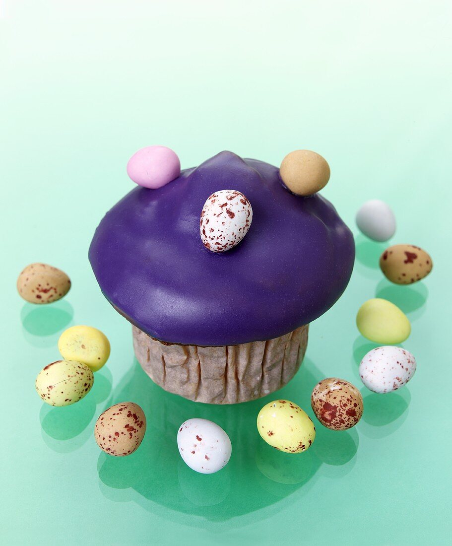 Muffin with purple icing and chocolate eggs