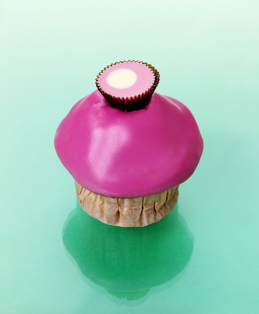 Muffin mit rosa Zuckerguss und Konfekt