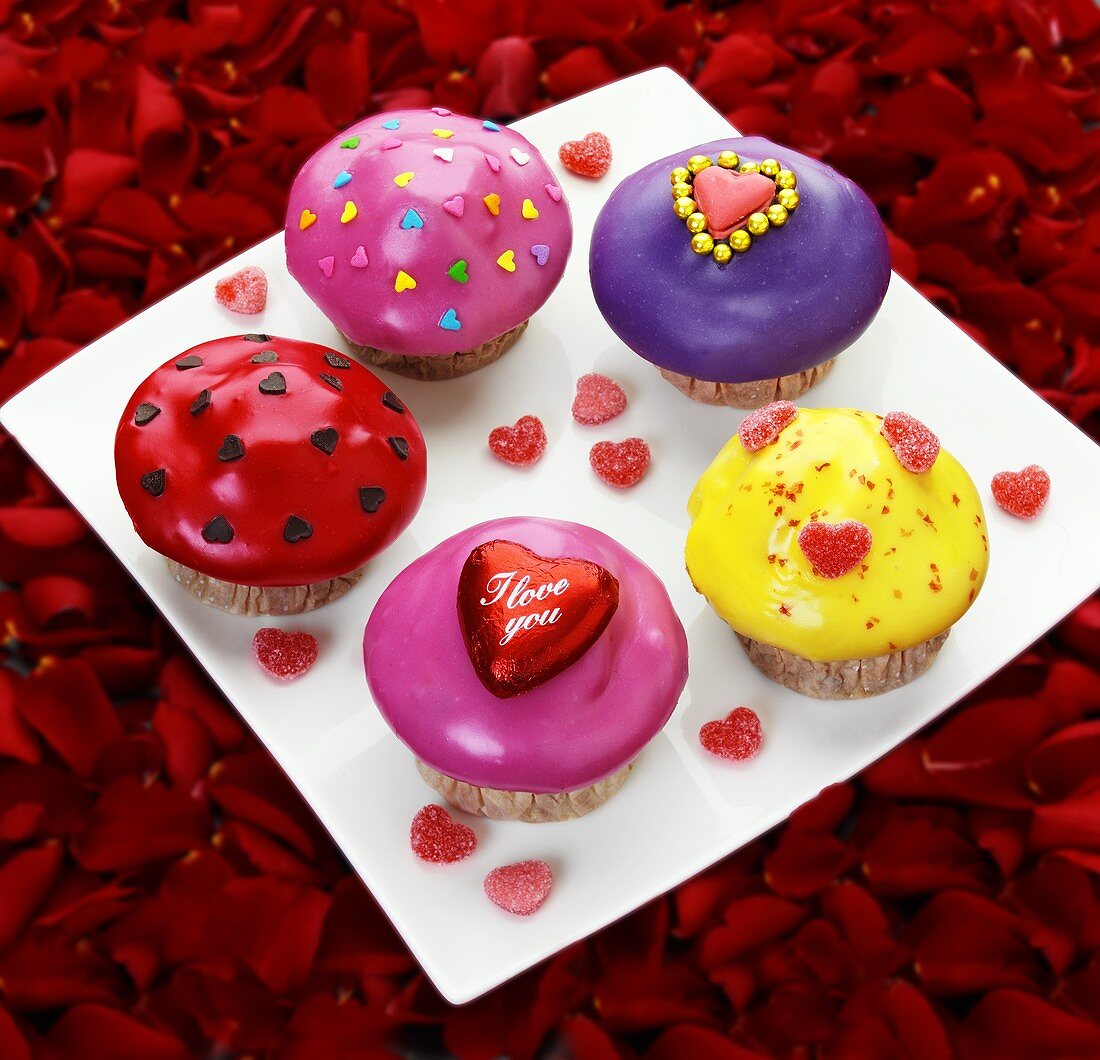 Plate of muffins decorated with hearts on rose petals