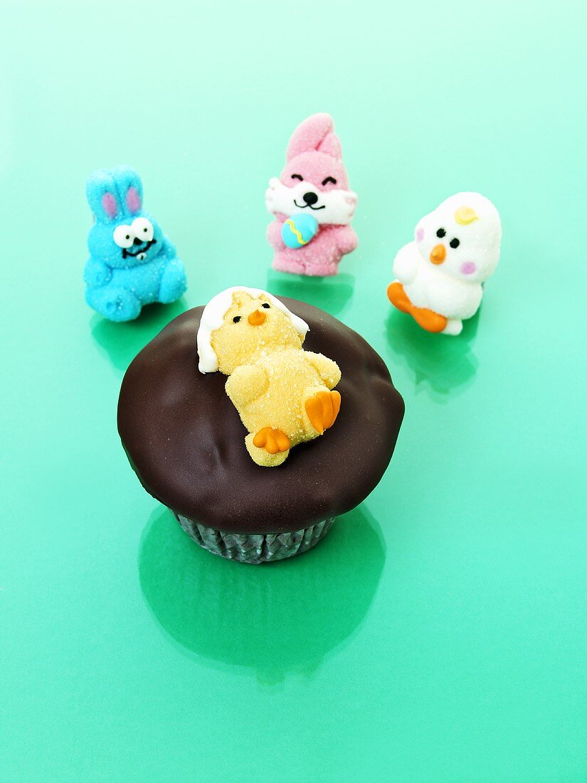 Muffin with chocolate icing and jelly chick for Easter