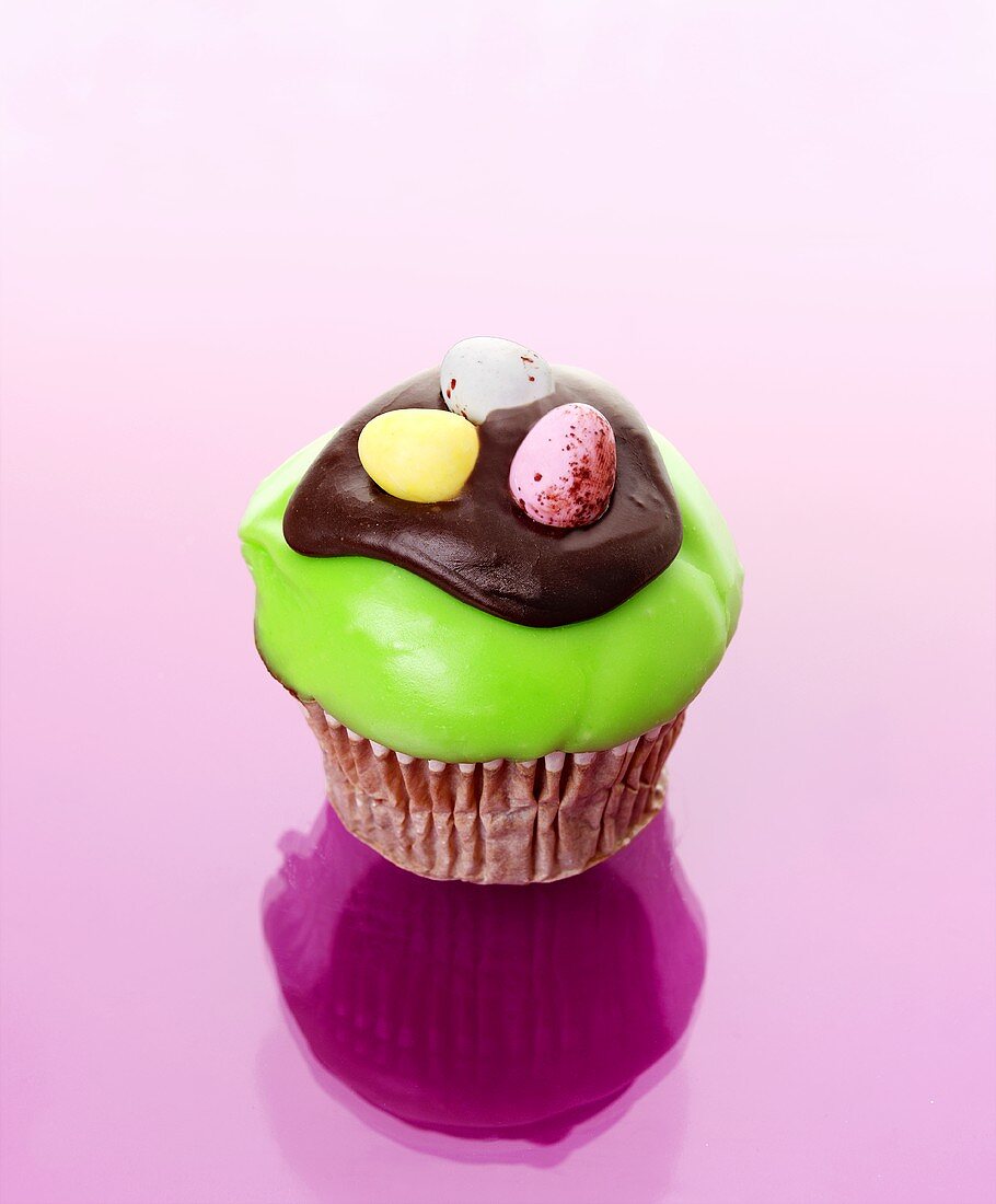Muffin with green icing and chocolate eggs