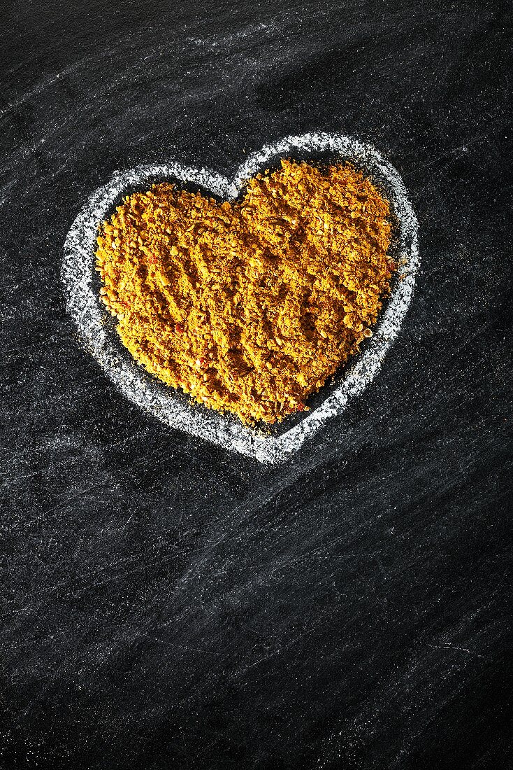 Curry powder in a heart drawn in chalk on a slate
