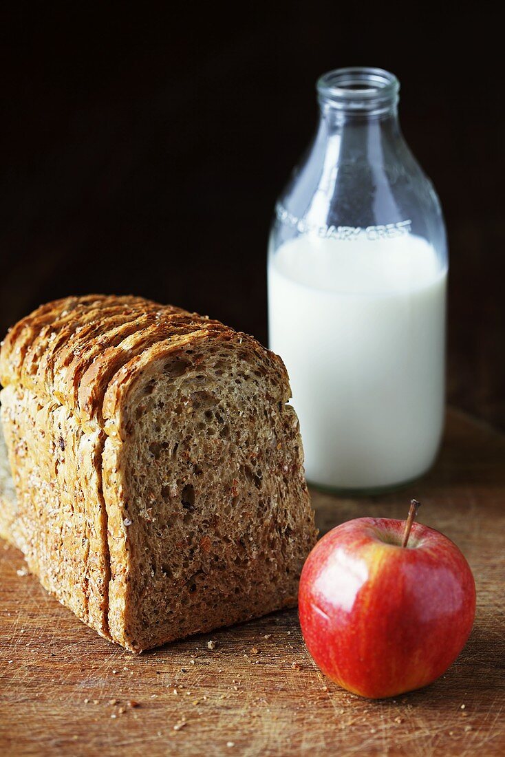 Brotscheiben mit einer Flasche Milch und einem Apfel