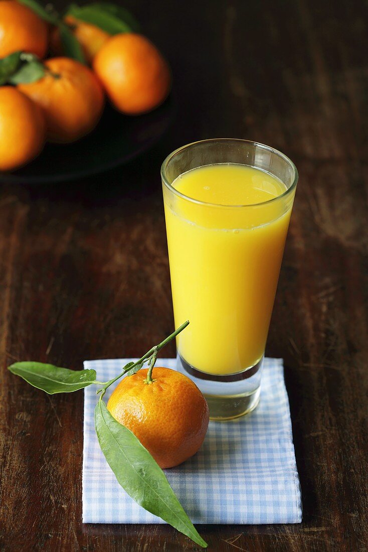 Glas Orangensaft mit frischen Mandarinen