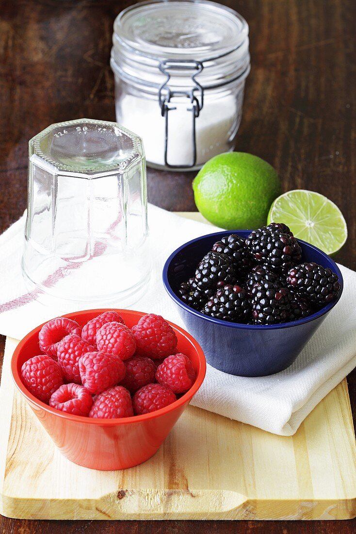 Fresh berries with sugar, limes and preserving jars