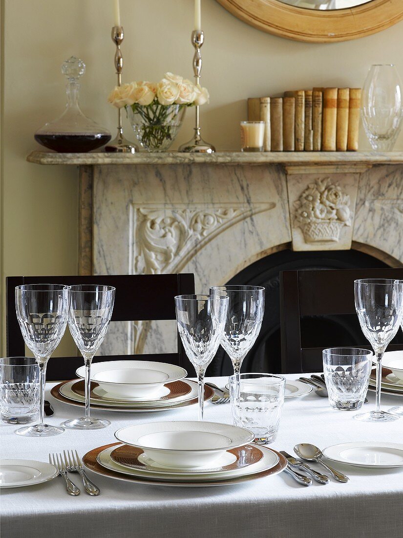 Elegantly laid table in front of fireplace