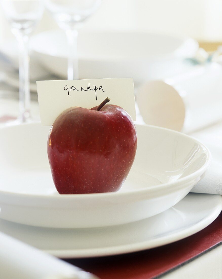 Weihnachtliches Gedeck mit rotem Apfel und Schild