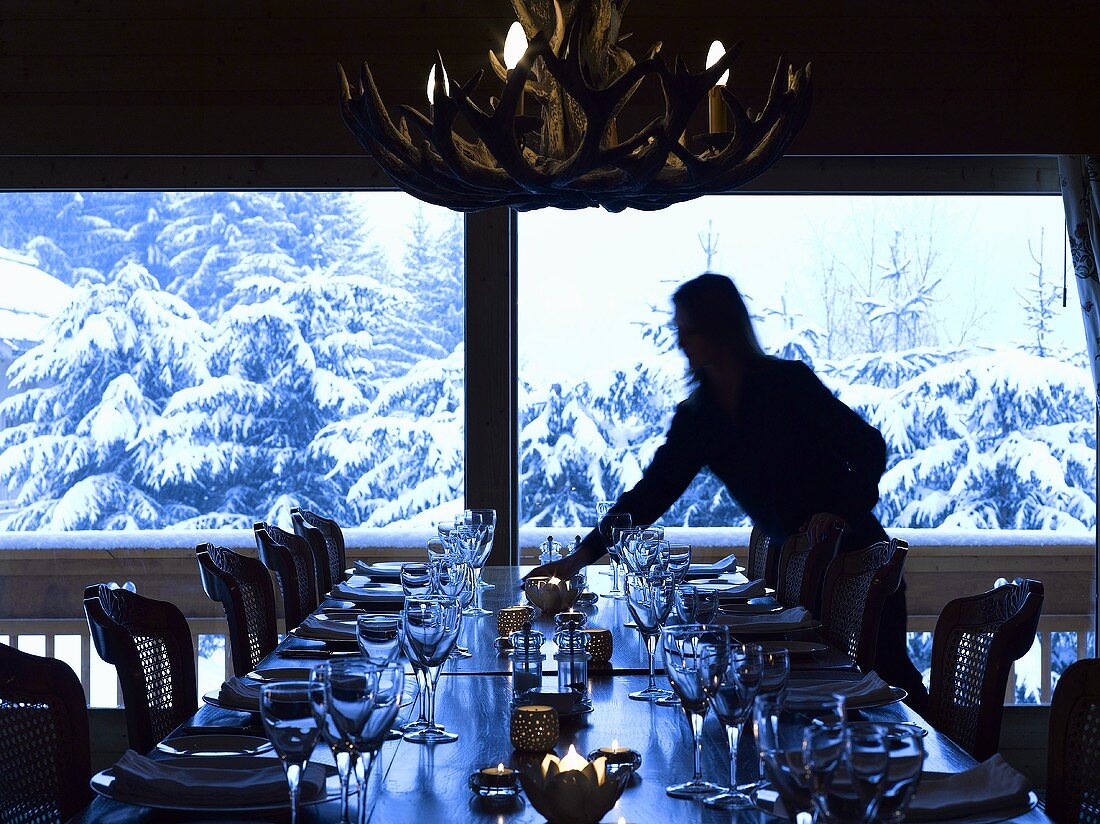 Laid table in front of window with view of snow-covered trees