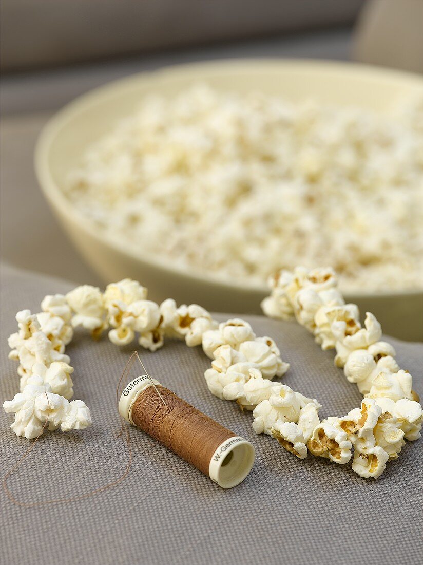 Kette aus Popcorn mit Nadel und Faden