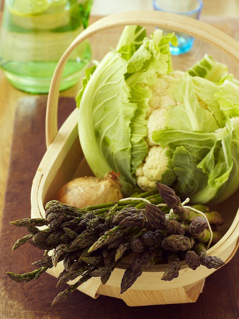 Grüner Spargel, Blumenkohl und Zwiebel in einem Körbchen