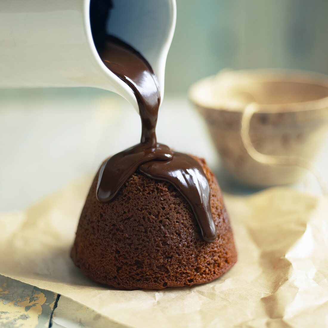 Gebackenen Schokoladenpudding mit Schokosauce übergiessen