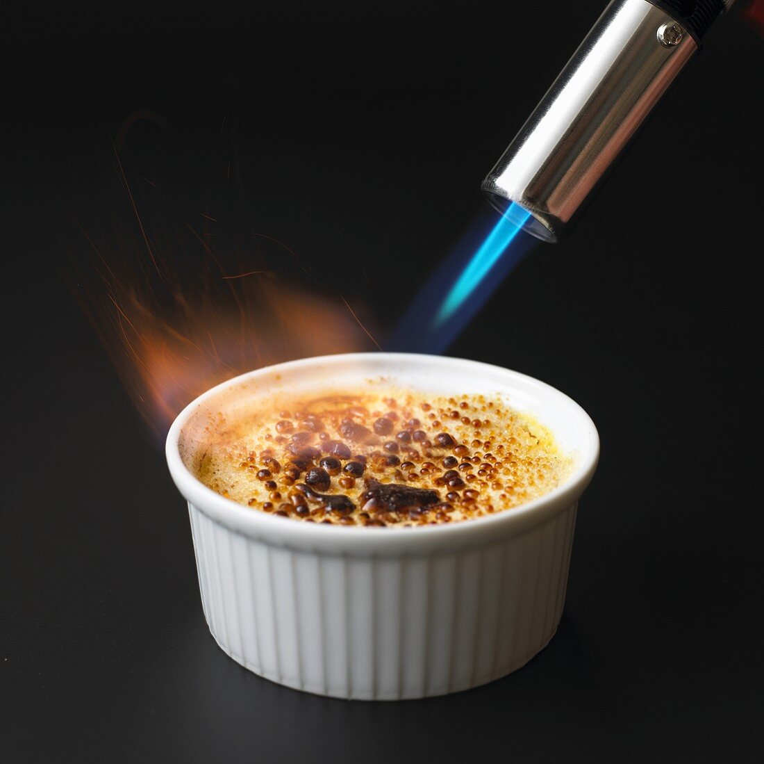 Caramelising crème brûlée with blowtorch