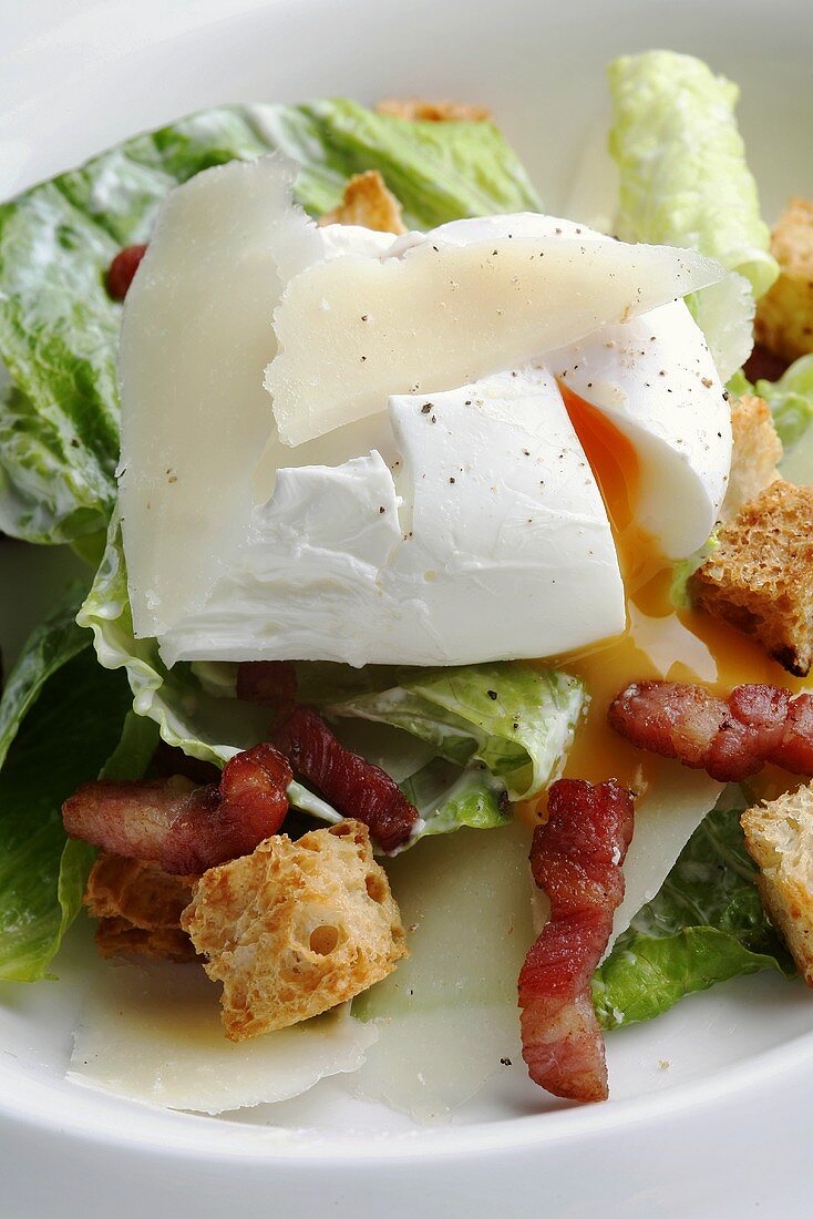 Caesar salad with poached egg, bacon and croutons