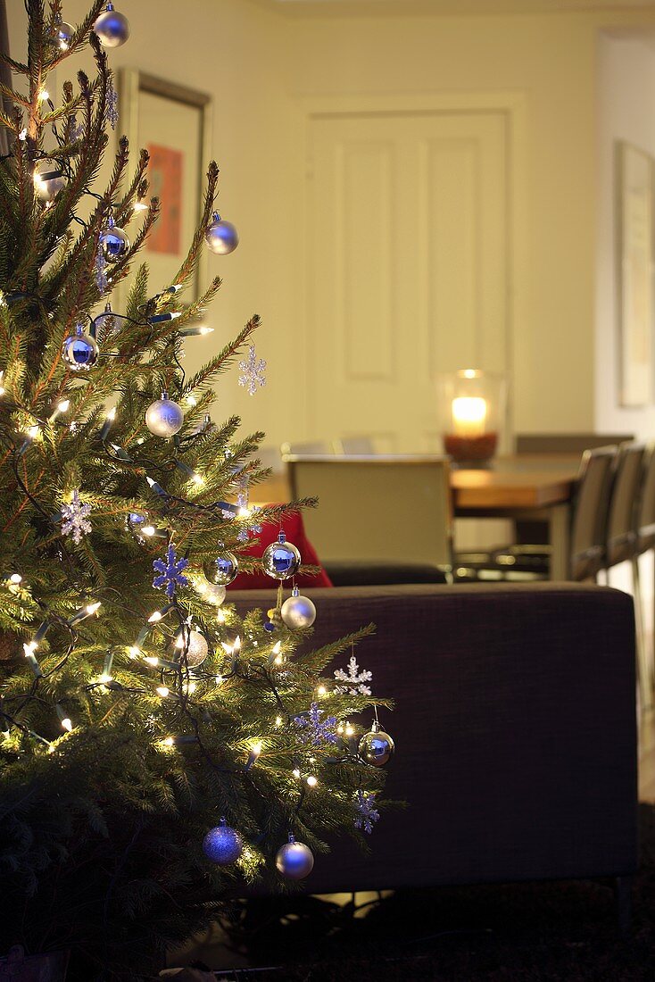 Decorated Christmas tree, dining table in background