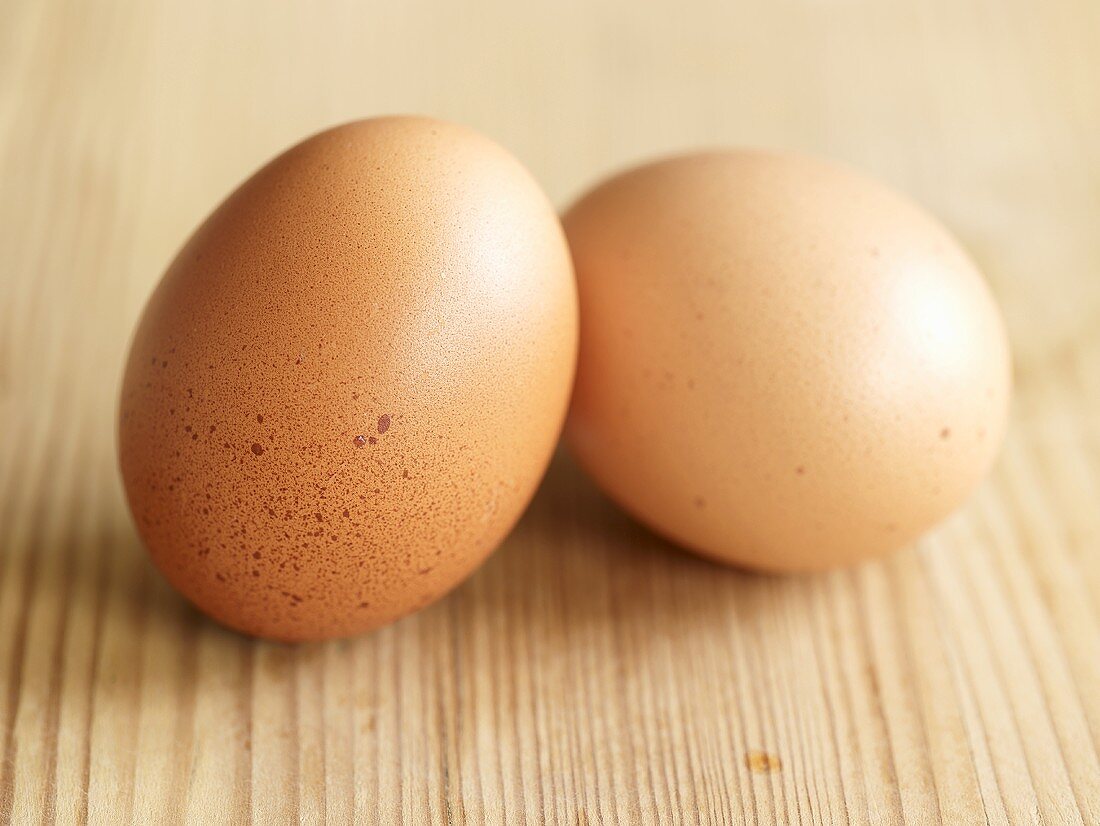 Two hens' eggs on wooden background