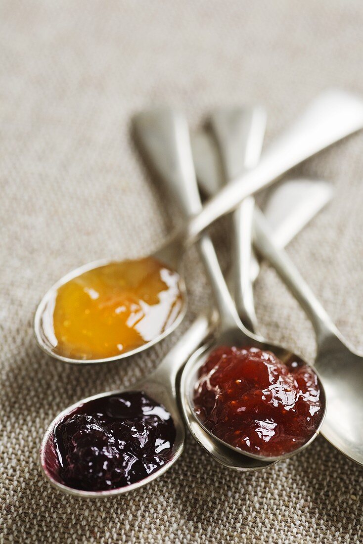 Spoonfuls of apricot, raspberry and blackberry jam