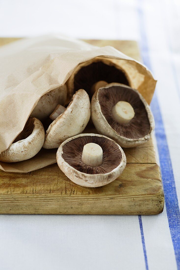 Portobello Pilze in Papiertüte auf Schneidebrett