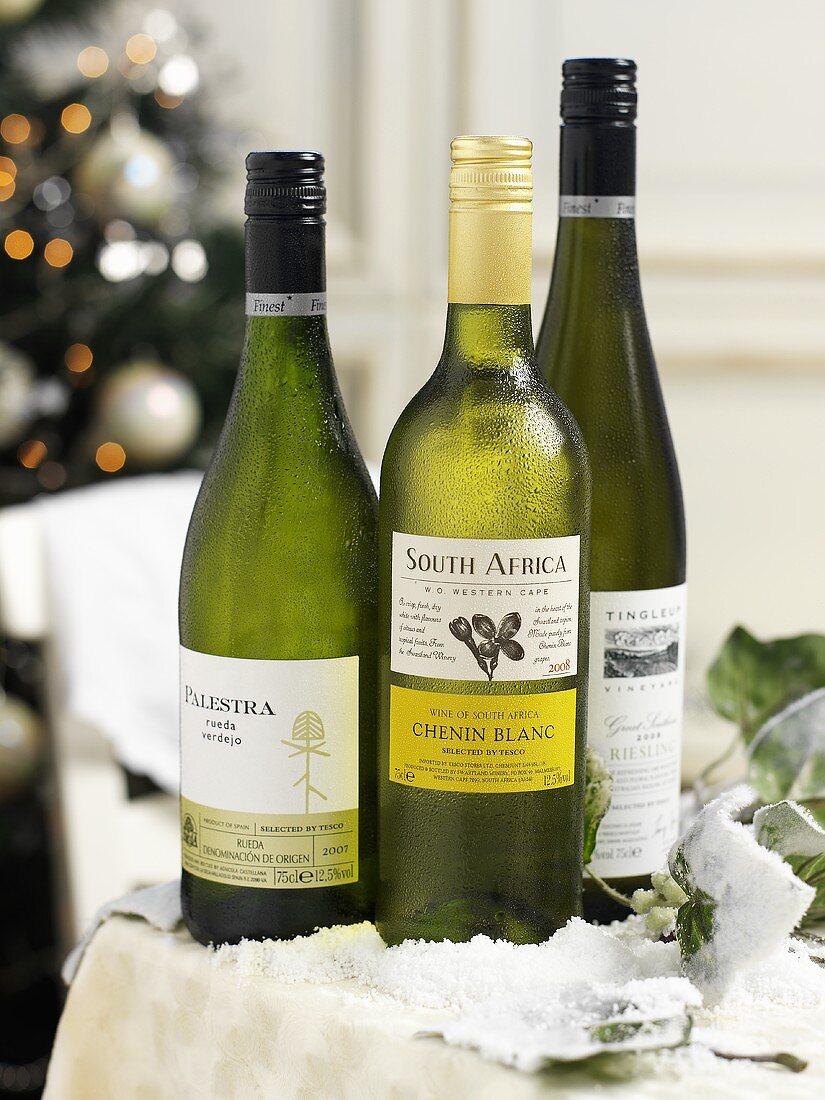 Verschiedene Weissweinflaschen mit Etikett zu Weihnachten