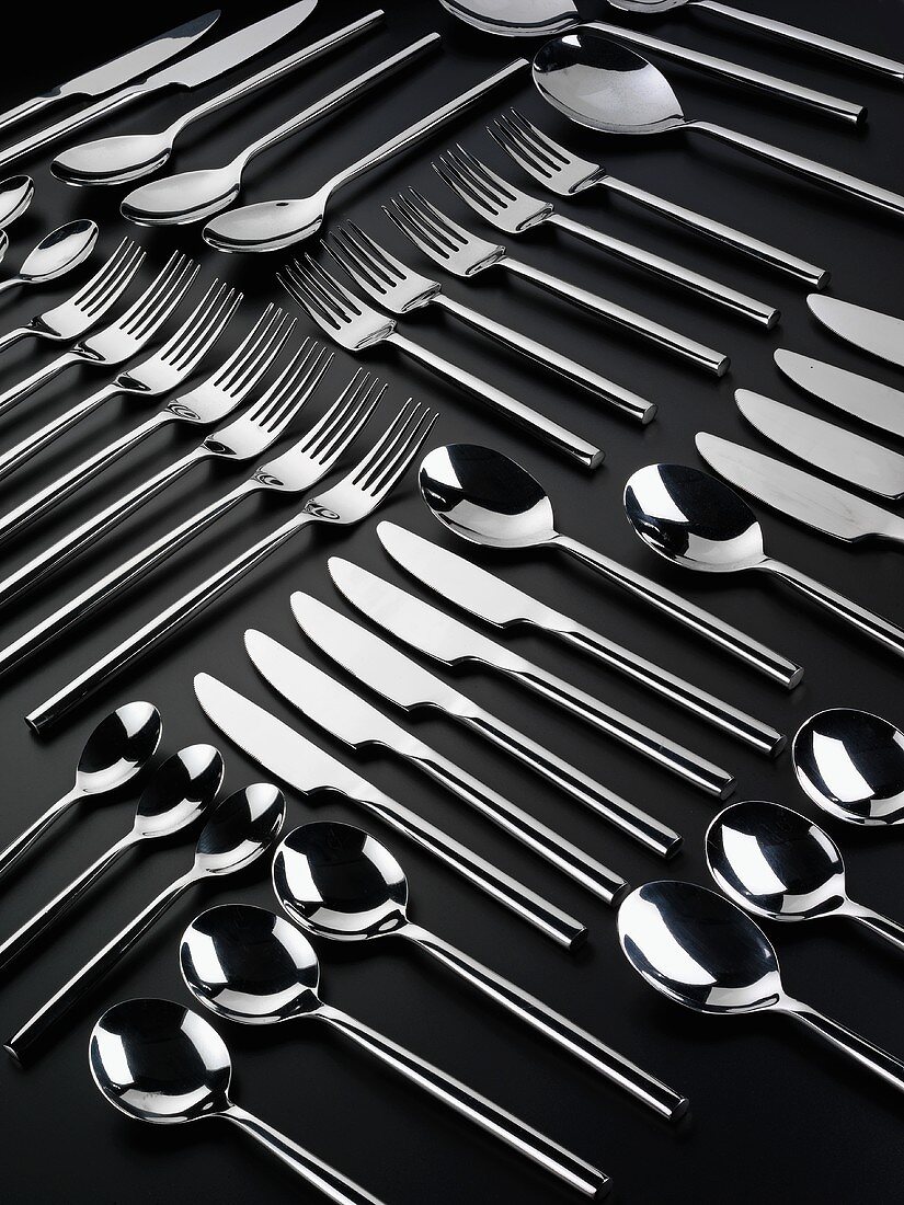 Knives, forks and spoons arranged in rows