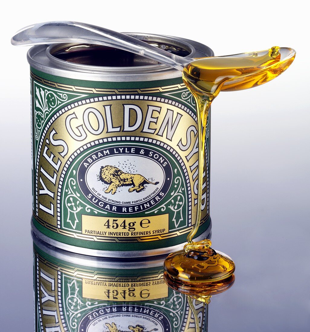 Golden syrup trickling off a spoon